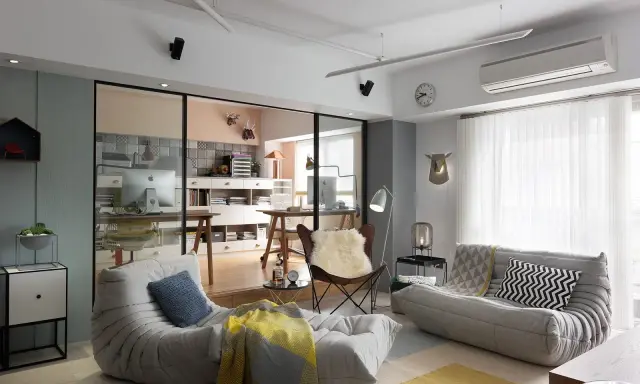 Un espacio que irradia hygge que es: sofás cómodos, mantas cálidas y un rincón de trabajo acogedor.