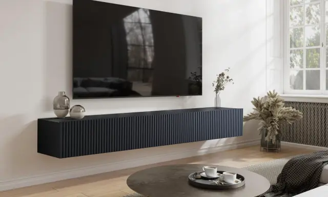 Un mueble flotante oscuro para salón, con un gran televisor encima. El mueble es demasiado estrecho para el tv no cabe en mueble salón.