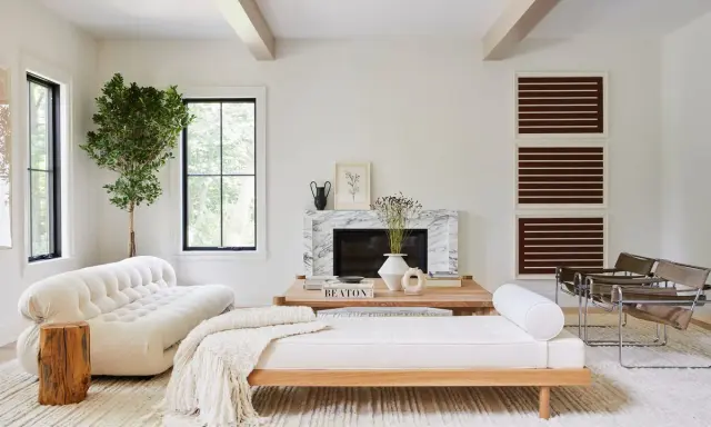 Salones blancos y madera: un sofá blanco texturizado, un diván de madera, chimenea de mármol y sillas de cuero.