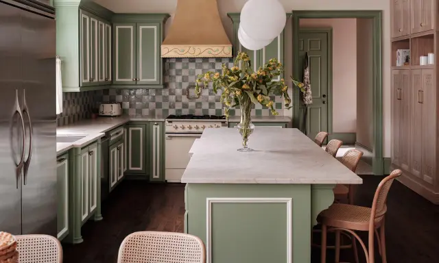 Elegantes cocinas verdes con gabinetes de madera clara, encimeras de mármol y un toque de color en la campana de la estufa.