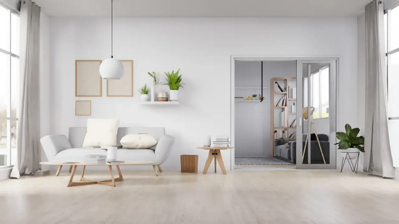 Un sal&oacute;n moderno con sof&aacute; gris, mesa de centro de madera y un suelo claro que invita a cambiar el suelo de tu casa.