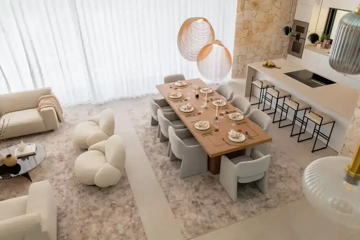 Comedor moderno con mesa de madera, sillas tapizadas y l&aacute;mparas colgantes. El dise&ntilde;o, inspirado en el feng shui, promueve la armon&iacute;a y el equilibrio.