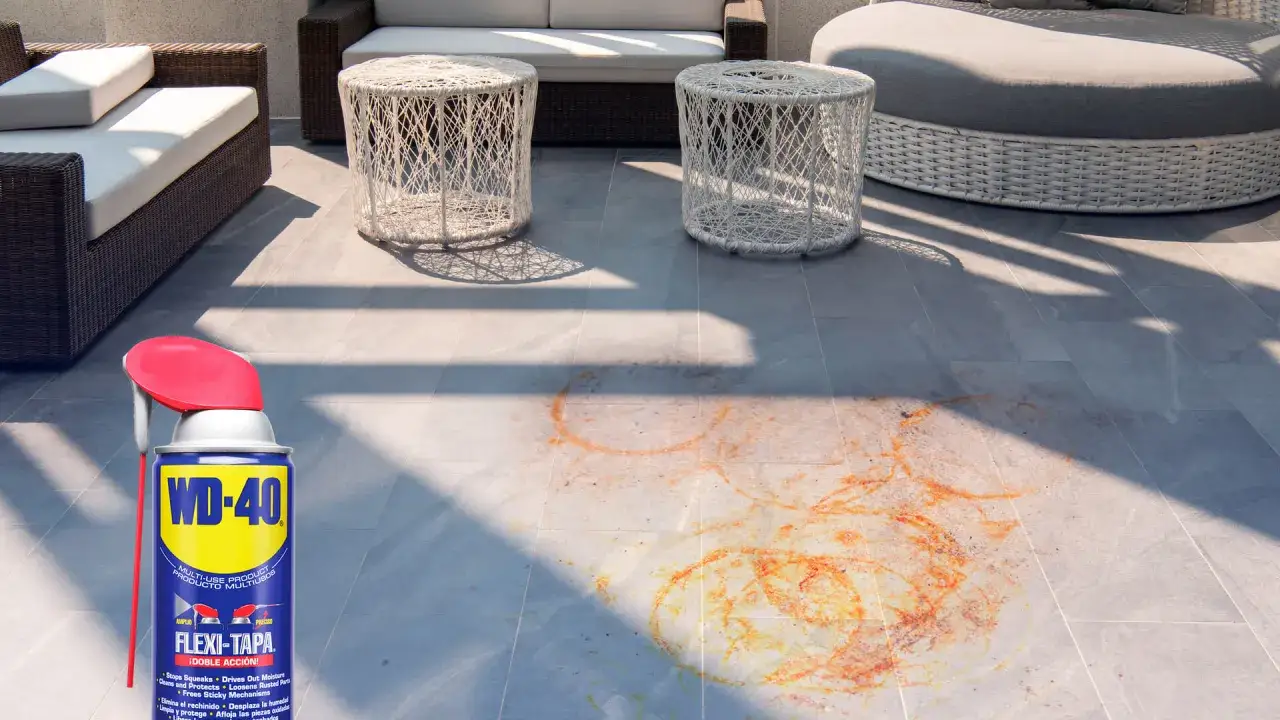 WD-40 listo para ayudarte a saber como quitar el óxido del suelo. Manchas anaranjadas en baldosas grises de terraza.