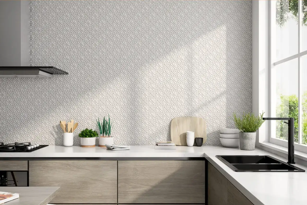 Elegante decoracion pared cocina con azulejos texturizados en relieve. Encimera blanca con plantas, utensilios y vajilla.