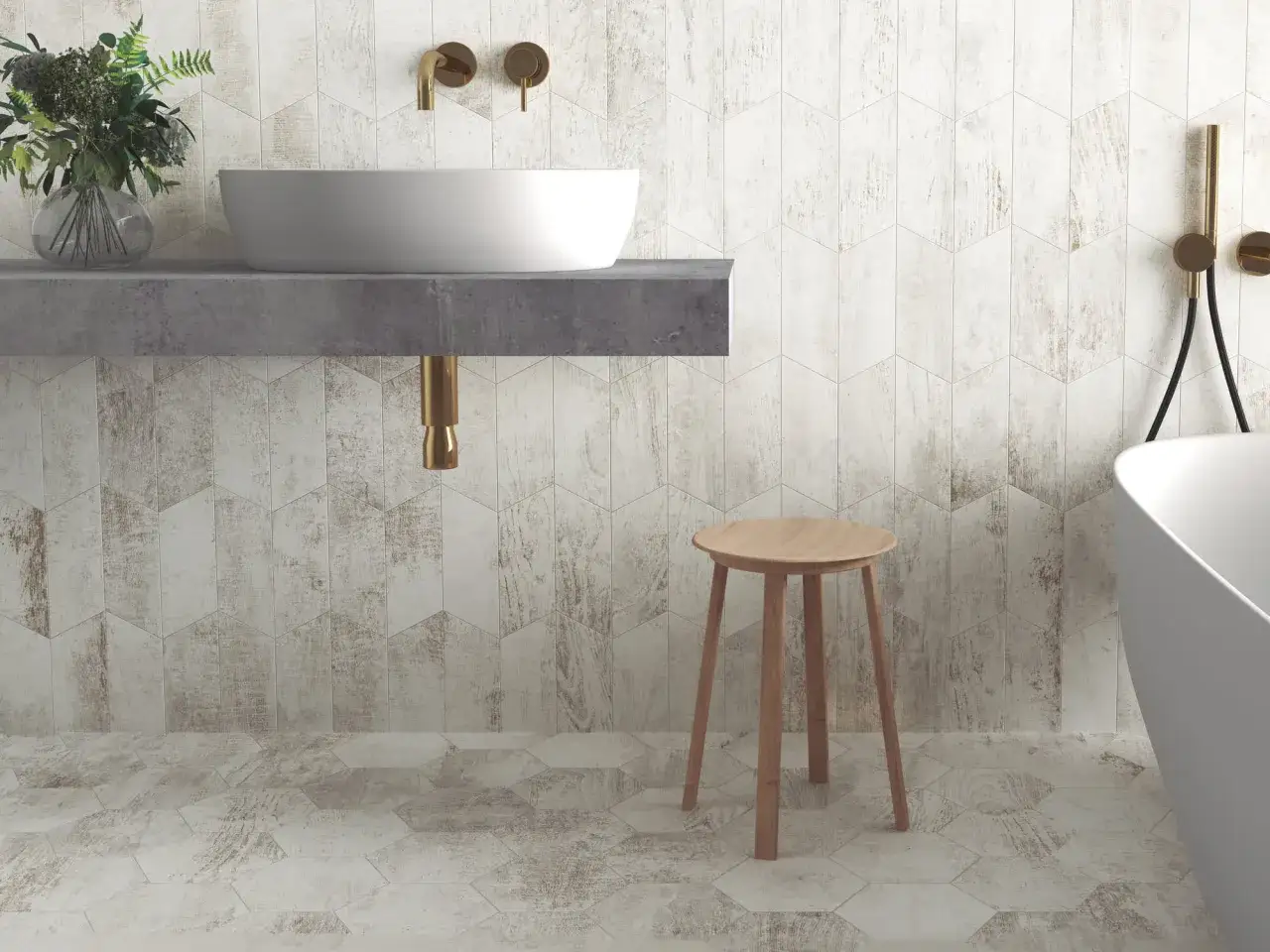 Baño moderno con lavabo sobre encimera de hormigón y grifería dorada. Las paredes y el suelo están revestidos con azulejos Oporto de diseño hexagonal y aspecto madera desgastada.